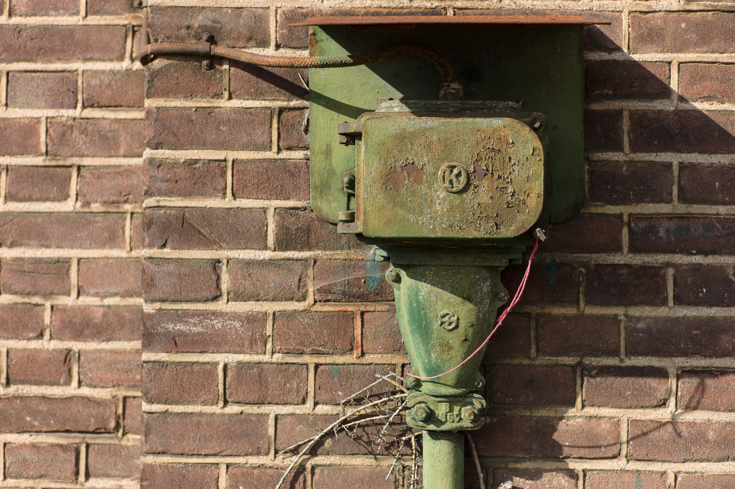 Een roestend schakelkastje aan een muur in Amsterdam Oost.
